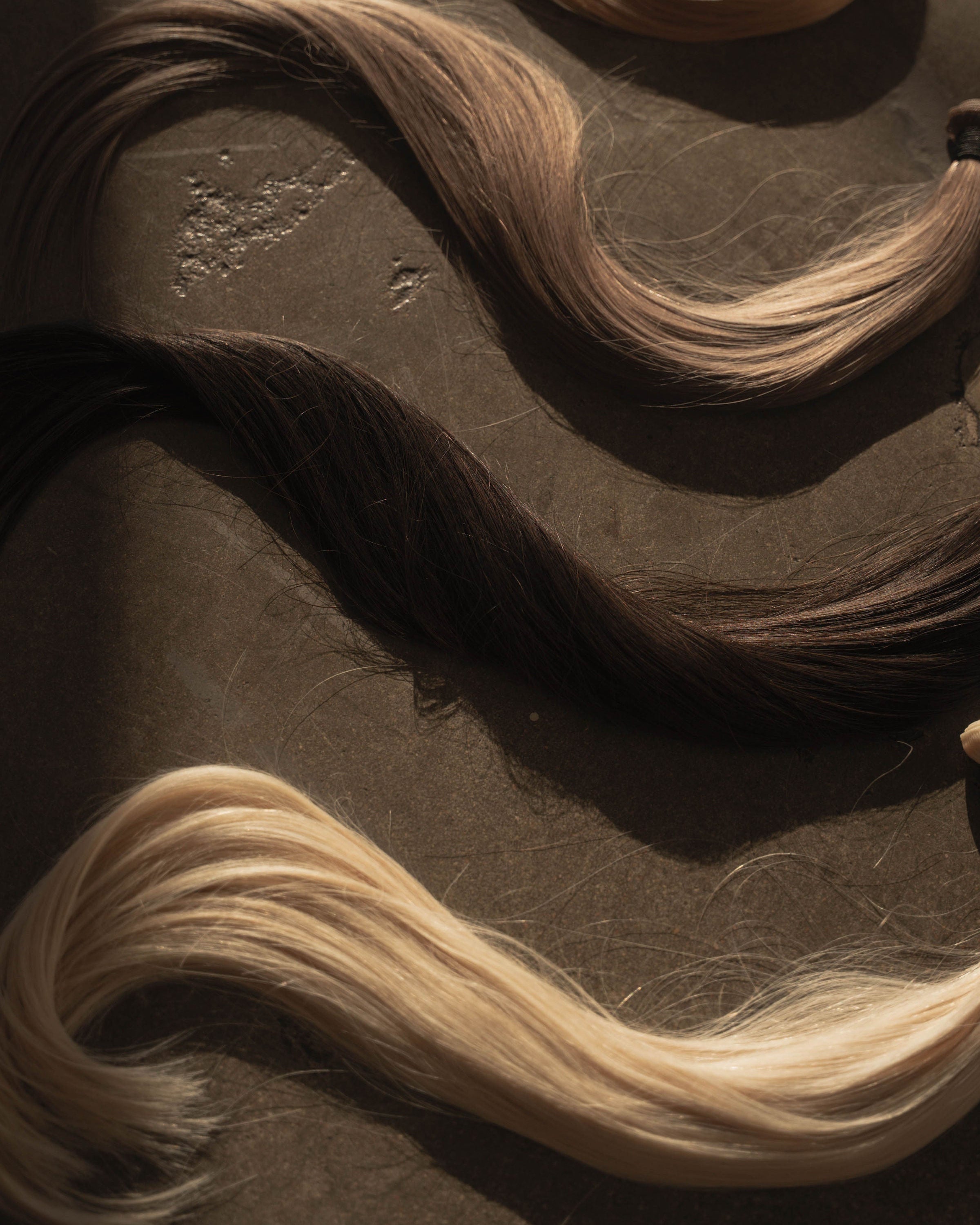 Blonde hair extensions on a dark surface
